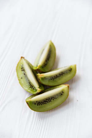 Kiwifruit sliced in four parts on white surfaceの写真素材