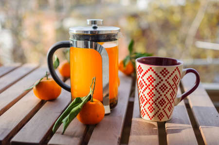 Glass teapot, mug and tangerines on wooden tableの写真素材