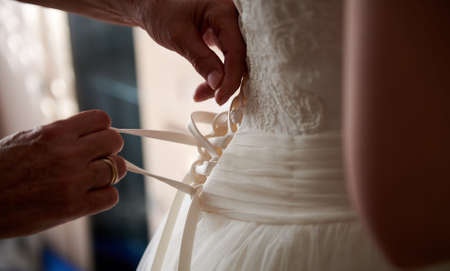Dressing bride for wedding. Close view on handsの写真素材