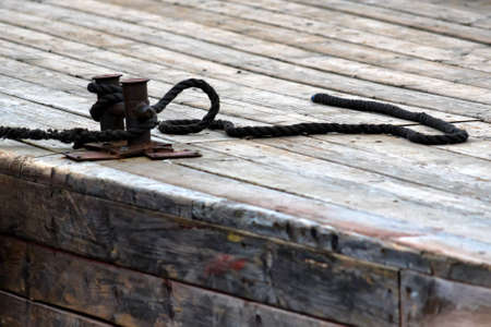 Mooring lines on a bollard on wooden pier closeの写真素材