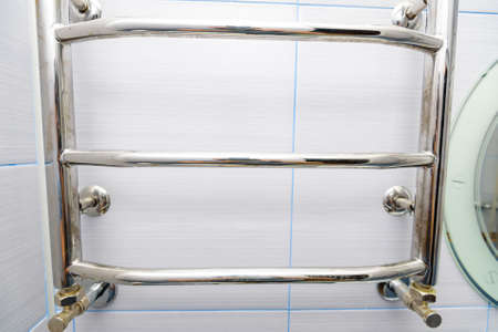 Stainless steel towel hanger on wall in bathroomの写真素材