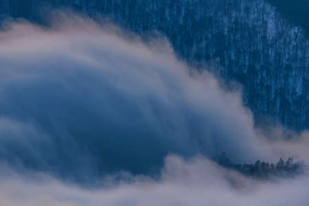 Beautiful distant winter mountains landscape with mist