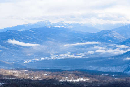Beautiful distant winter mountains landscape with cloudsの写真素材