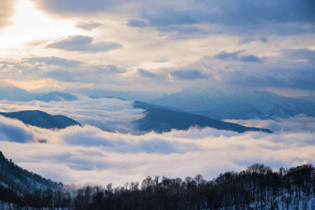 Beautiful distant winter mountains and skyscape with mistの写真素材