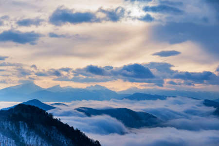 Beautiful distant winter mountains and skyscape with mistの写真素材