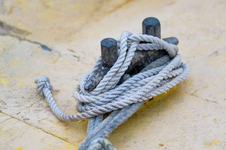 Close up of boat rope tied to nautical cleat hitch on boatの写真素材