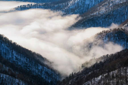 Beautiful distant winter mountains landscape with mistの写真素材