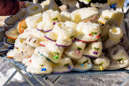 Close up many white woolen shoes for children on saleの写真素材