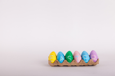 Easter eggs in egg carton on a solid background in studioの写真素材
