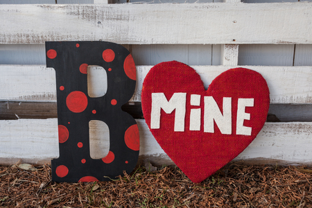 Be mine sign on a white wood background with red mine valentines heartsの写真素材