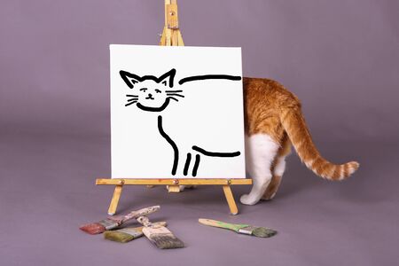 White painters canvas with cat illustration painted in black paint real cat tail and back side showing paint brushes scatteredの写真素材