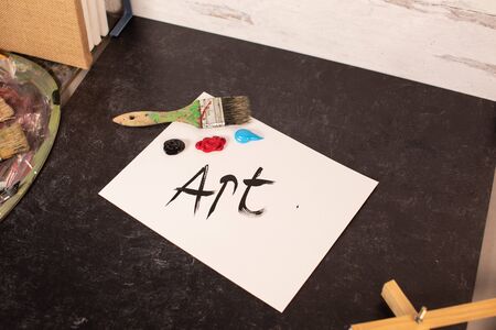 Artist workspace the word art painted in black paint art brush and materialsの写真素材