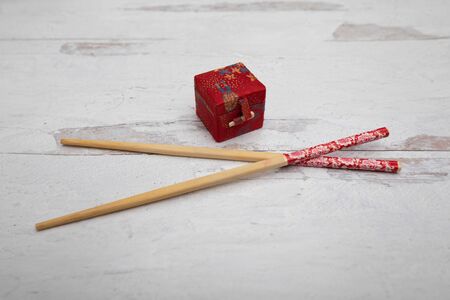 Chopsticks and oriental red gift box on wooden backgroundの写真素材