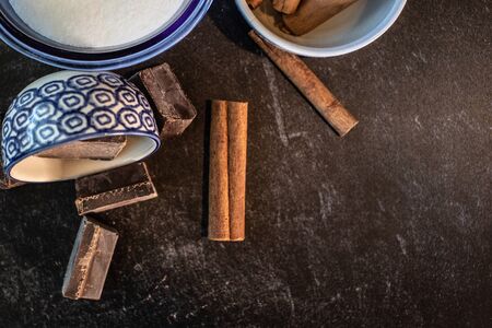 Close up of cinnamon sticks white sugar and baking chocolateの写真素材