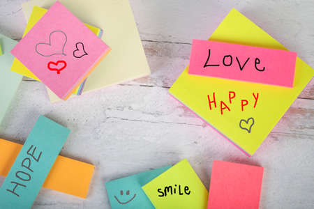 Assorted posted note pads with love happy smile hearts and smiling face frame dead space in the...