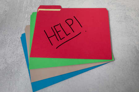 Word help handwritten on red office file folder fanned out assorted colored foldersの写真素材
