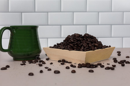 Green ceramic coffee mug with whole roasted coffee beansの写真素材