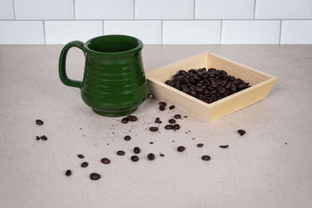 Coffee ceramic green cup with whole dark roasted coffee beansの写真素材