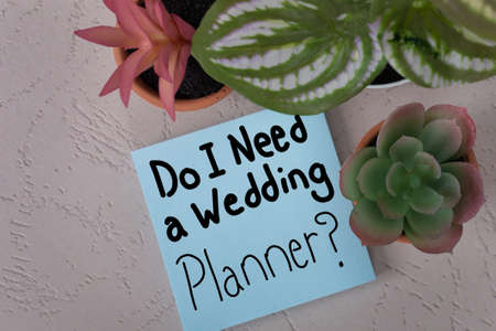 Do I Need A Wedding Planner? handwritten on square blue posted note wedding day organization and prep assistanceの写真素材