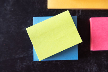 Fat lay background blank colorful note pads stacked against black background