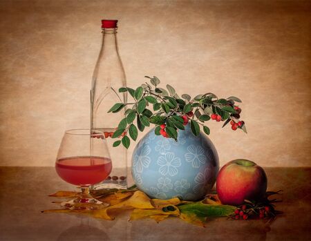 Still life with bottle, glass, and greenery.の写真素材