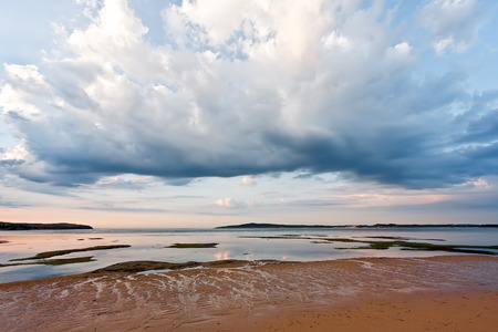 Beautiful clouds over shallow waters and sandy beach. Minimalistic Australian landscapeの写真素材