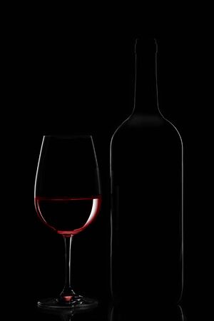 Red wine bottle and wine glass on black backgroundの写真素材