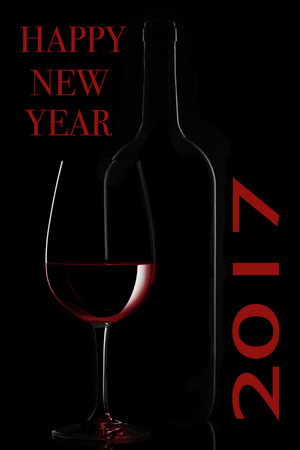 Red wine bottle and wine glass on black backgroundの写真素材