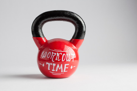 Red kettlebell with Workout Time lettering written on it isolated on white with copy spaceの写真素材