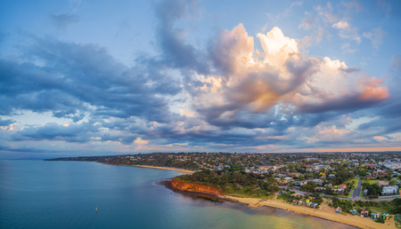 Aerial panorama of coastline, beaches and Australian suburban area at sunset with beautiful clouds. Mornington Peninsula, Melbourne, Victoria, Australiaの写真素材