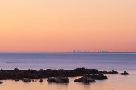 Melbourne CBD skyline at sunset in the distance with rock formations on the foreground.の写真素材