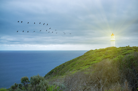 Lighthouse shining protective light over ocean.の写真素材