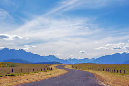 Pastoral winding country road and mountains in Fiordland, South Island, New Zealandの写真素材