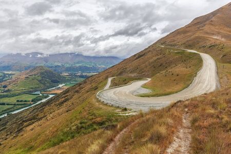 Winding road uphill to the Remarkables Ski Area with beautiu views, Queenstown, New Zealand.の写真素材