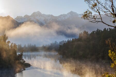 View of Southern Alps from lake Matheson in the early morning mist. South Island, New Zealand.の写真素材