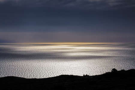 Smooth water surface with light and shadow play at sunset, Bluff Hill lookout, New Zealand.の写真素材