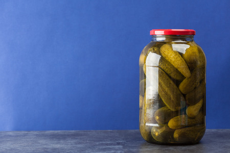 Big jar with pickles on blue background with copy spaceの写真素材