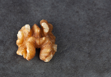 Extreme closeup of a walnut on a dark grungy surface with copy space.