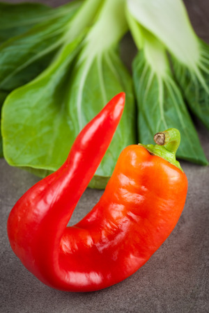 Sweet red chilli and bok choi leafs. Healthy raw ingredients. Shallow depth of field.の写真素材