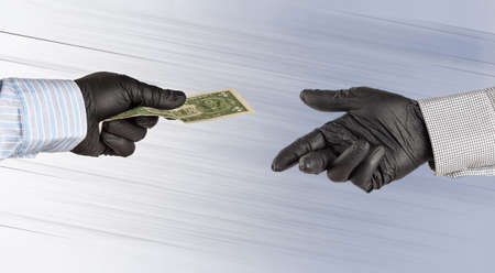 Hands in gloves transfer one american dollar.