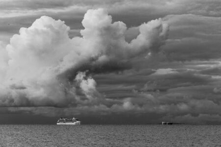 Cruise liner sailing under stormy clouds across Mornington Peninsula, Australia. Image in black and white.の写真素材