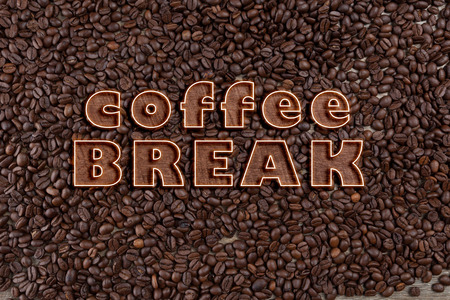 Coffee Break text on scattered roasted coffee beans on wooden tableの写真素材