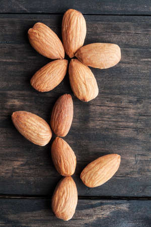 Almonds arranged in flower shape with petals and leafs closeup with copy spaceの写真素材