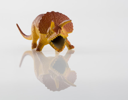 Yellow angry dinosaur toy isolated on whiteの写真素材