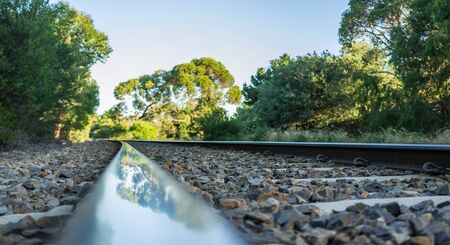 Closeup of rail track with tree reflection. Shallow depth of field.の写真素材