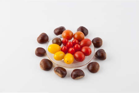 Chestnuts and cherry tomatoes culinary composition isolated on white.の写真素材