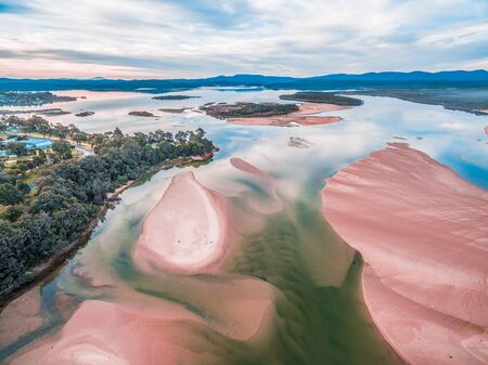 Aerial landscape - beautiful sky reflecting in shallow ocean water and sandの写真素材