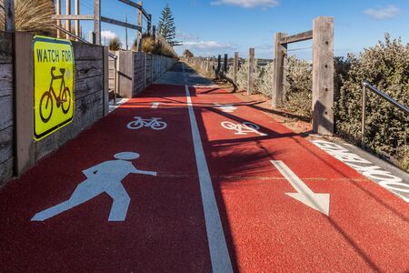 Watch for bicycles and pedestrian signs on shared empty footpath vanishing in the distance on bright sunny dayの写真素材