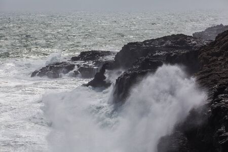 Waves breaking hard on rocks - extreme force of nature
