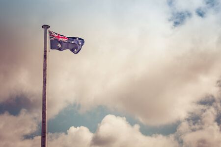 Australian flag on a flag pole with beautiful sky as background and copy spaceの写真素材